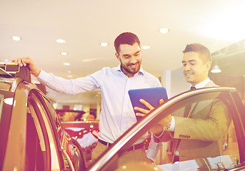 Image showing happy man with car dealer in auto show or salon