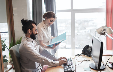 Image showing happy creative team with computer in office