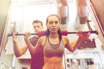 Image showing man and woman with barbell flexing muscles in gym