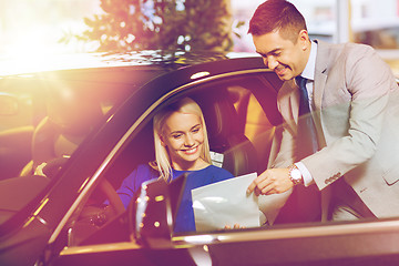 Image showing happy woman with car dealer in auto show or salon