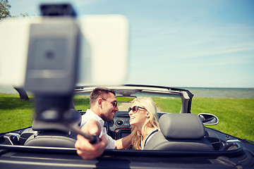 Image showing happy couple in car taking selfie with smartphone