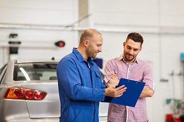 Image showing auto mechanic with clipboard and man at car shop