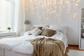 Image showing bedroom with bed and christmas garland at home