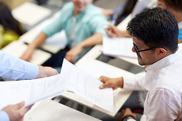 Image showing teacher giving exam test to student man at lecture