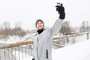 Image showing man taking selfie with smartphone in winter 