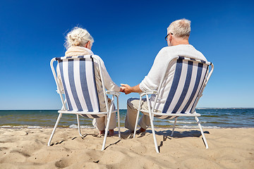 Image showing senior couple sitting on chairs at summer beach