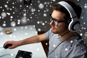 Image showing man in headset playing computer video game at home