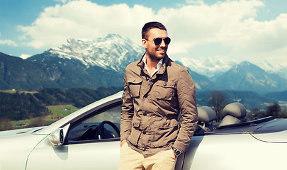 Image showing happy man near cabriolet car over mountains