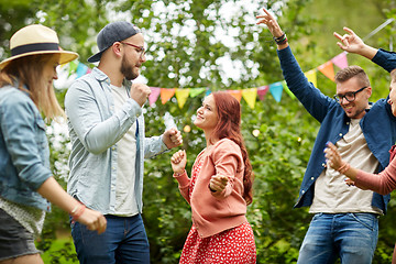 Image showing happy friends dancing at summer party in garden