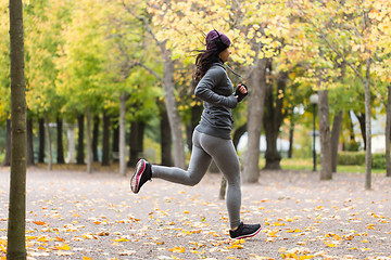 Image showing close up of young woman running in autumn park