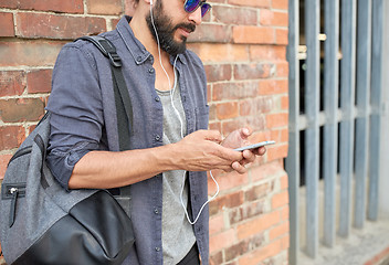 Image showing man with earphones, smartphone and bag on street