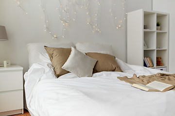 Image showing bedroom with bed and christmas garland at home