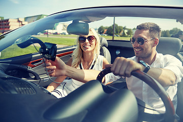 Image showing happy couple using gps navigator in cabriolet car