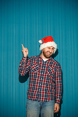 Image showing Smiling christmas man wearing a santa hat