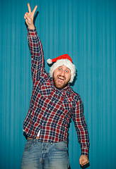 Image showing Smiling christmas man wearing a santa hat