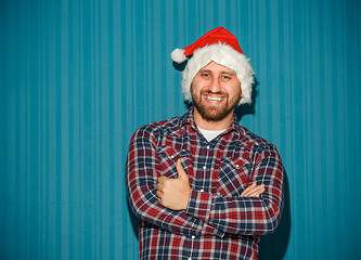 Image showing Smiling christmas man wearing a santa hat