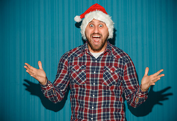 Image showing Smiling christmas man wearing a santa hat