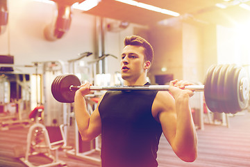 Image showing young man flexing muscles with barbell in gym