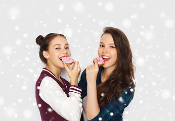 Image showing happy pretty teenage girls eating donuts