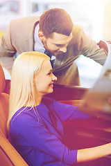 Image showing happy couple buying car in auto show or salon