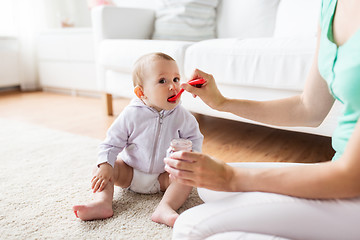 Image showing mother with spoon feeding little baby at home