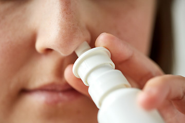 Image showing close up of sick woman using nasal spray