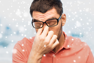 Image showing close up of tired man in eyeglasses rubbing eyes