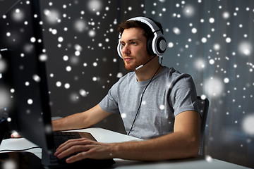 Image showing man in headset playing computer video game at home