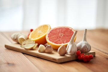 Image showing citrus, ginger, garlic and rowanberry on wood