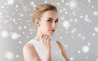 Image showing woman in white dress with diamond jewelry and snow