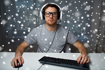 Image showing man in headset playing computer video game at home