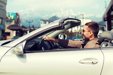 Image showing happy man driving cabriolet car over city in japan