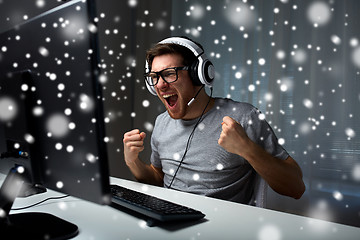 Image showing man in headset playing computer video game at home