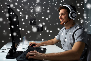 Image showing man in headset playing computer video game at home