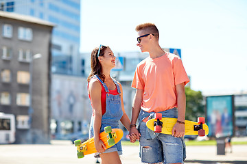 Image showing teenage couple with skateboards on city street