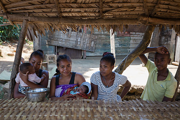 Image showing Malagasy woman with baby resting under shelter