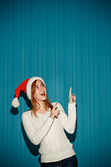 Image showing Surprised christmas girl wearing a santa hat