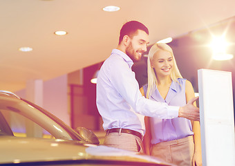 Image showing happy couple buying car in auto show or salon