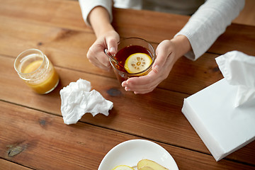 Image showing close up of ill woman drinking tea with lemon