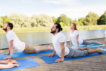 Image showing group of people making yoga exercises outdoors