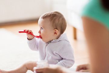 Image showing mother and baby with spoon eating at home