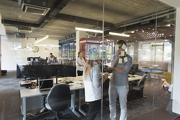 Image showing young couple at modern office interior writing notes on stickers