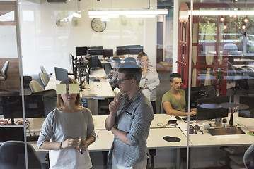 Image showing young couple at modern office interior writing notes on stickers