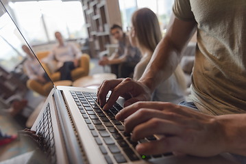 Image showing close up of male hands while working on laptop