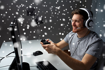 Image showing man in headset playing computer video game at home