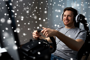 Image showing man playing car racing video game at home