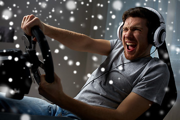 Image showing man playing car racing video game at home