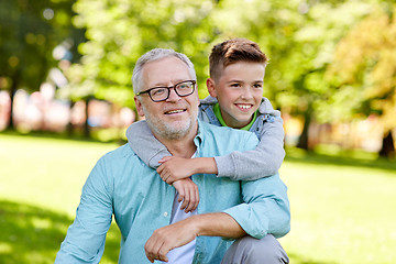 Image showing grandfather and grandson hugging at summer park