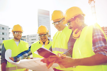 Image showing group of builders with tablet pc and blueprint