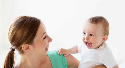 Image showing happy young mother with little baby at home